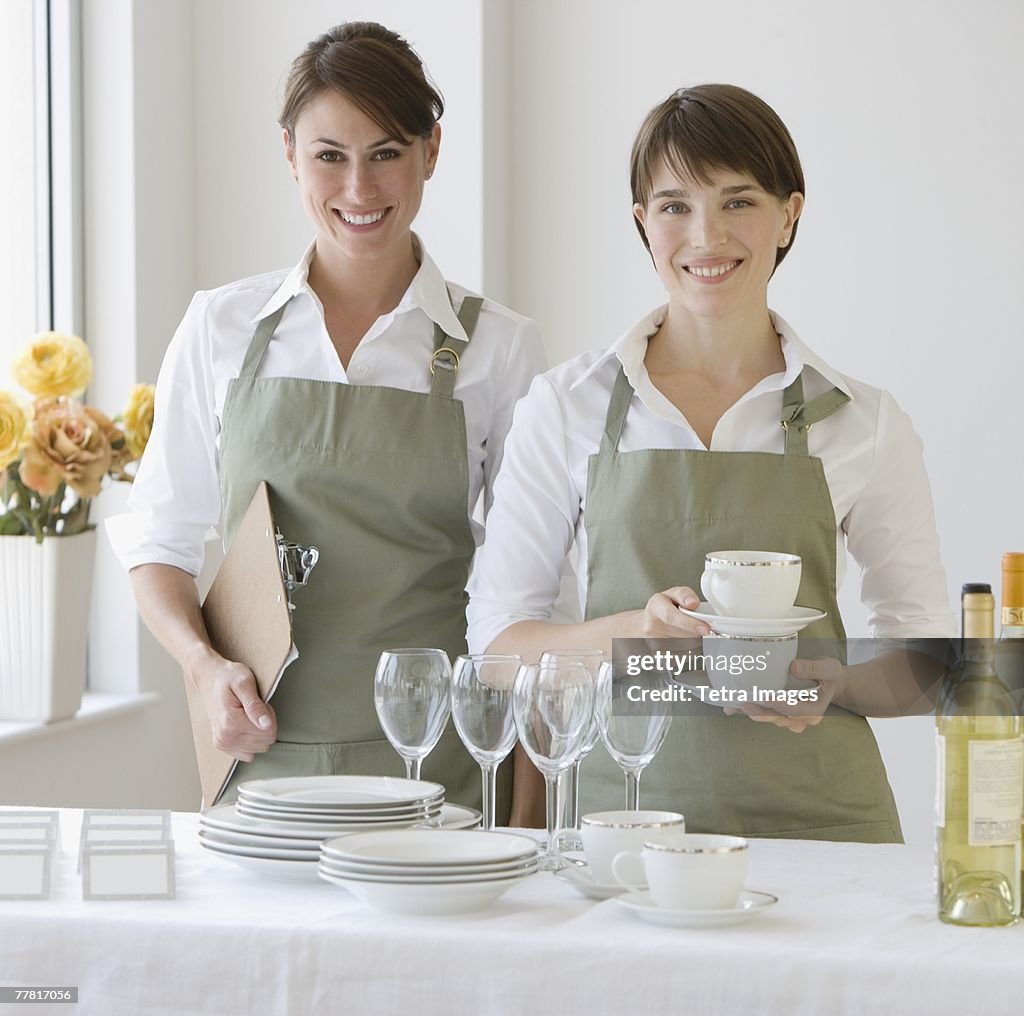 Two female caterers with dishware