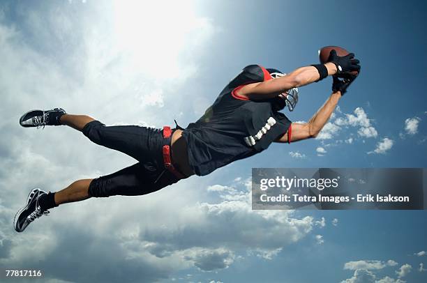 low angle view of football player jumping - american football player catch stock pictures, royalty-free photos & images