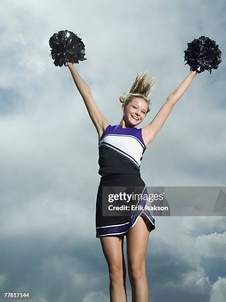 cheerleader with pom poms jumping - white pom pom stock pictures, royalty-free photos & images