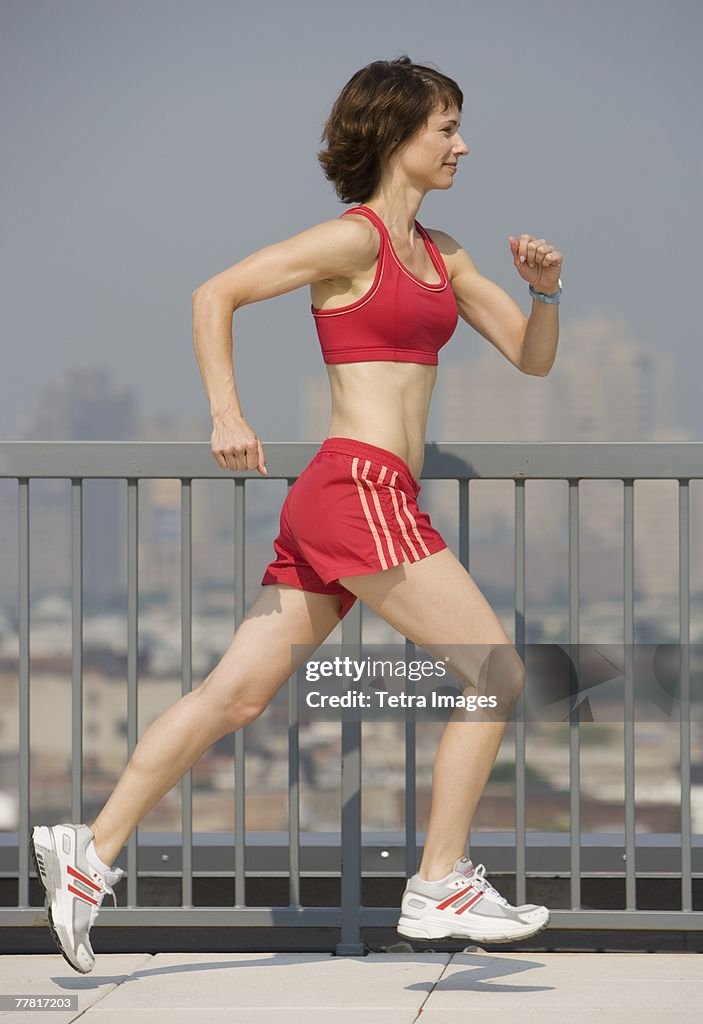 Woman jogging on urban sidewalk