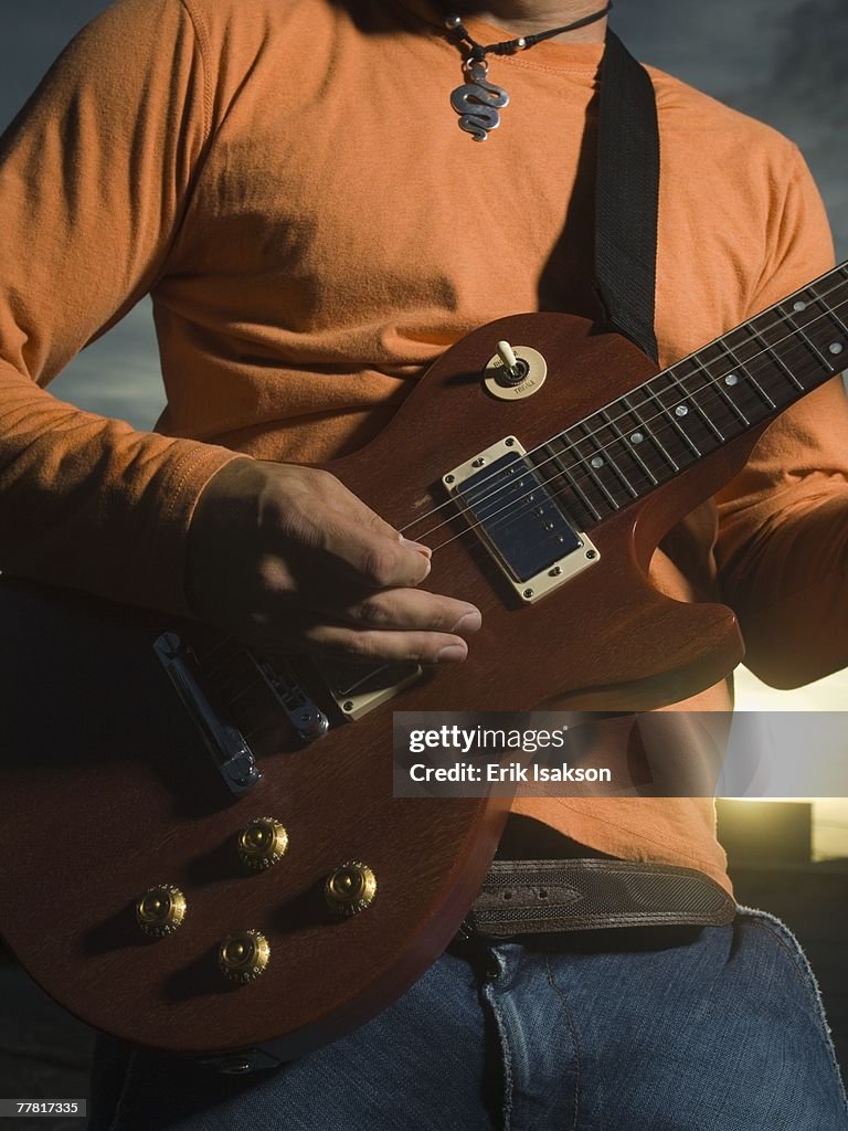 Close up of man playing guitar