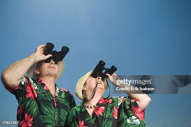 senior couple looking through binoculars - caricatura fotografías e imágenes de stock