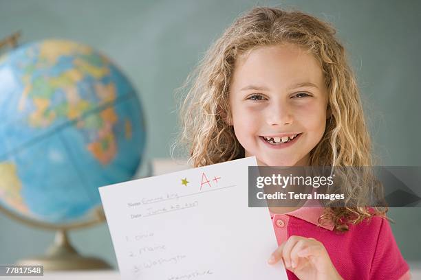 girl holding up a plus paper in classroom - school award stock pictures, royalty-free photos & images