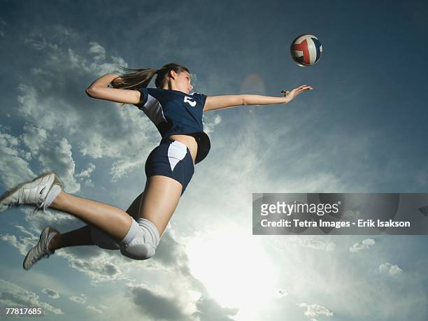 low angle view of volleyball player jumping - volleyball sport stock-fotos und bilder