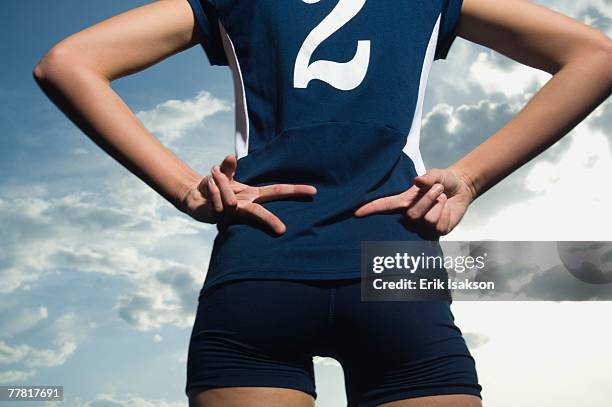 woman in athletic gear with hands behind back - alleen tienermeisjes stockfoto's en -beelden