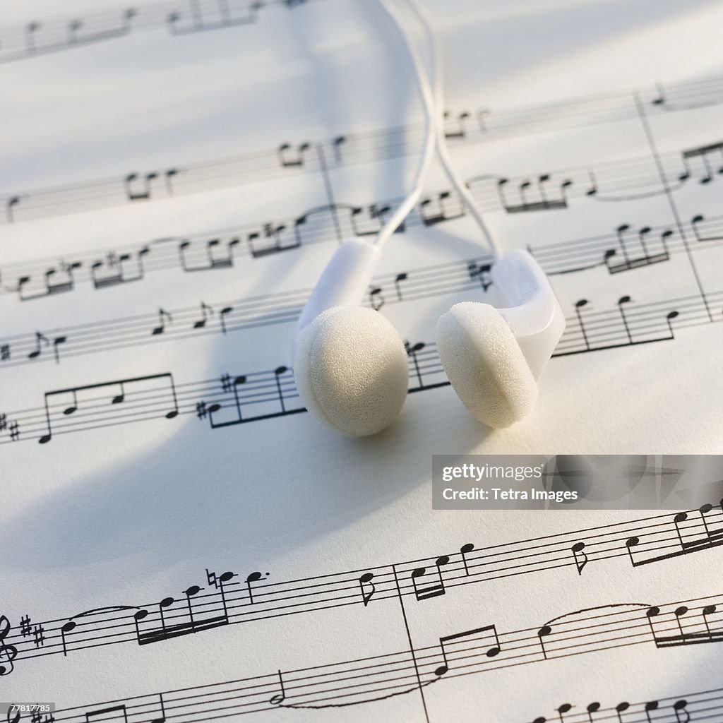 Close up of ear buds on sheet music