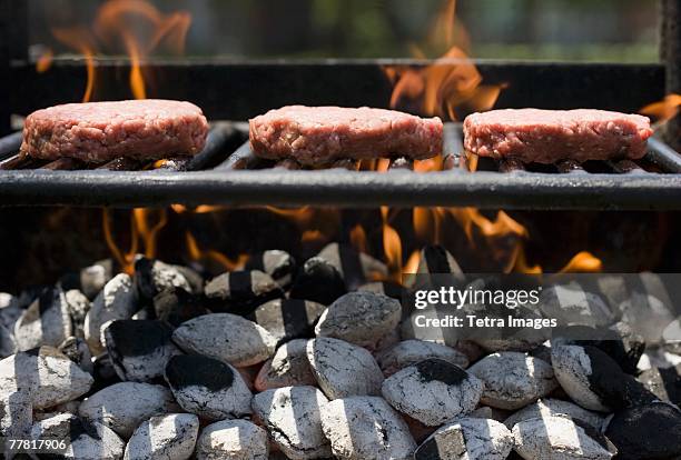 hamburgers cooking on grill - burger grill stock-fotos und bilder