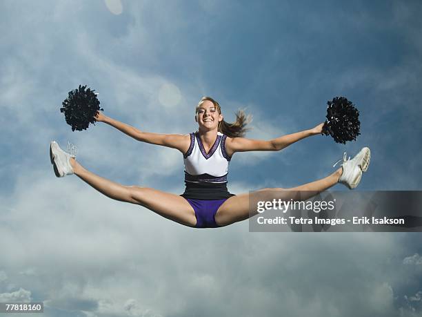 cheerleader with pom poms jumping - teen cheerleader - fotografias e filmes do acervo