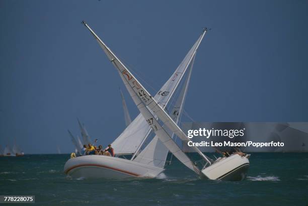 View of two sailing yachts racing during the Cowes Week regatta off the coast of the Isle of Wight in August 1987.