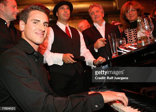 German Spyker MF1 driver Adrian Sutil plays piano at the opening of Mila Wiegands Exhibition "China" on November 08, 2007 in Duesseldorf, Germany.