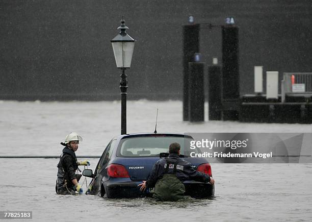 Firemen try to rescue a car at hte Fischmarkt during the flood on November 9, 2007 in Hamburg, Germany.