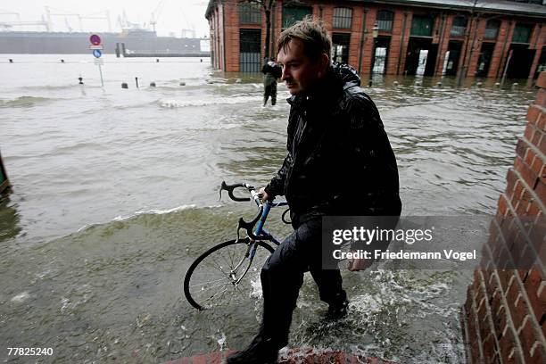 Man walks with his bike over the flooded Fischmarkt on November 9, 2007 in Hamburg, Germany.