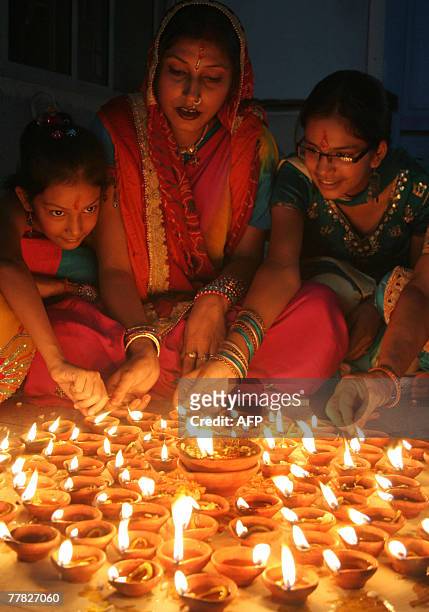 An Indian women lights clay lamps 'diya' in Siliguri, 09 November 2007 as they take part in celebrations for the Hindu Festival of Diwali, the...