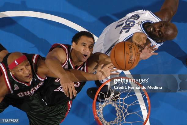 Charlie Villanueva and Dan Gadzuric of the Milwaukee Bucks and Adonal Foyle of the Orlando Magic go after a rebound during the game at Amway Arena on...