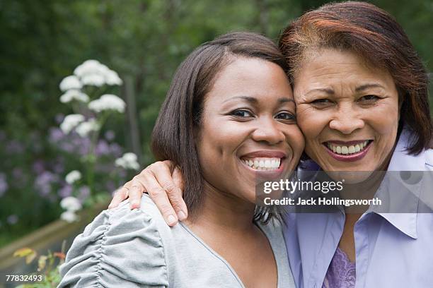 portrait of a senior woman and her daughter smiling - wange an wange stock-fotos und bilder