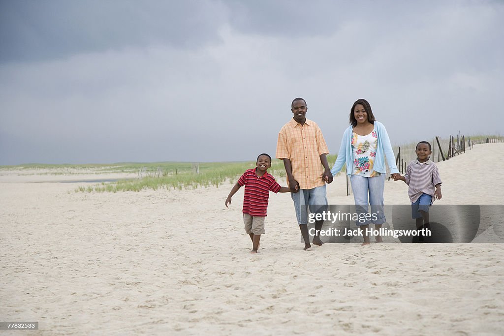 Couple with their two sons walking on the beach