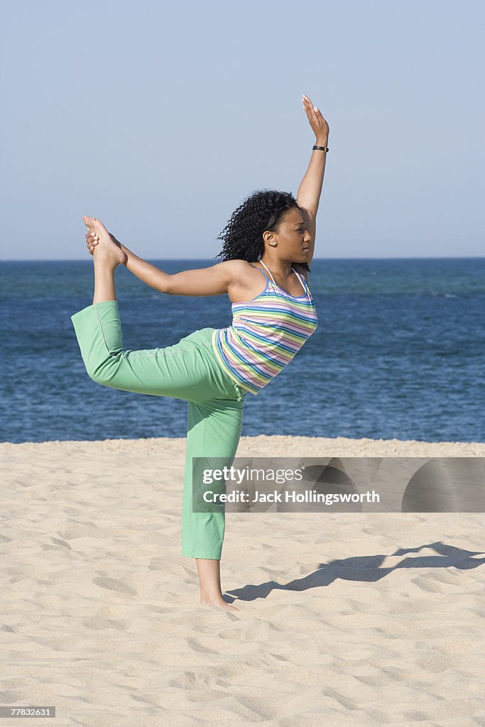 Young woman exercising on the beach