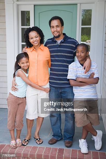 portrait a girl and a boy standing with their parents - family smiling at front door stock pictures, royalty-free photos & images