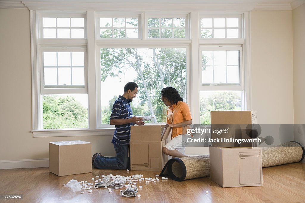 Side profile of a mid adult woman and a young man looking in a cardboard box