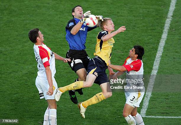 Eugene Galekovic of the United and Matthew Simon of the Mariners collade as they go for the ball during the round twelve A-League match between the...
