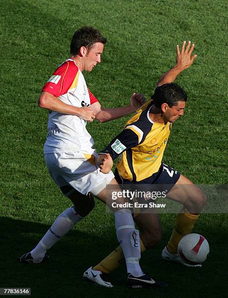 John Aloisi of the Mariners is defended by Robert Cornthwaite of the United during the round twelve A-League match between the Central Coast Mariners...