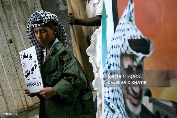 Palestinian boy dressed as late leader Yasser Arafat marches during a rally marking the third anniversary of his death in Rafah, southern Gaza Strip,...