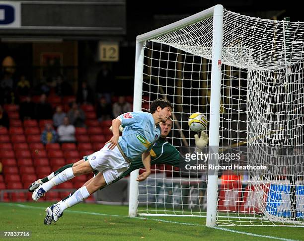 Keeper Dean Gerken and Kem Izzet of Colchester are helpless as Adam Johnson of Watford's shot goes in for the first goal during the Coca-Cola...