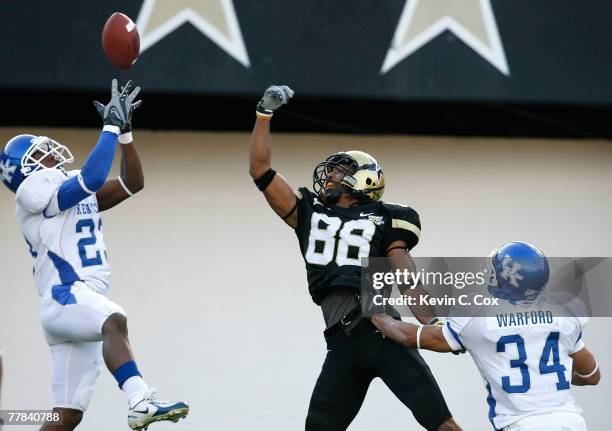 Cornerback Paul Warford defends as Shomari Moore of the Kentucky Wildcats nearly picks off a pass intended for receiver George Smith of the...