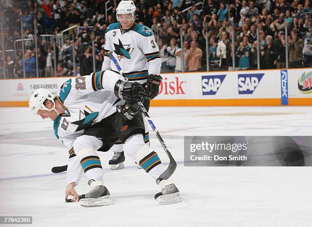 Doug Murray of the San Jose Sharks watches Jeremy Roenick of the San Jose Sharks pick up the puck after his 500th career goal during an NHL game...