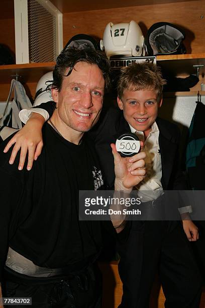 Jeremy Roenick of the San Jose Sharks and his son pose with the puck that gave him 500 career goals after a NHL game against the Phoenix Coyotes on...
