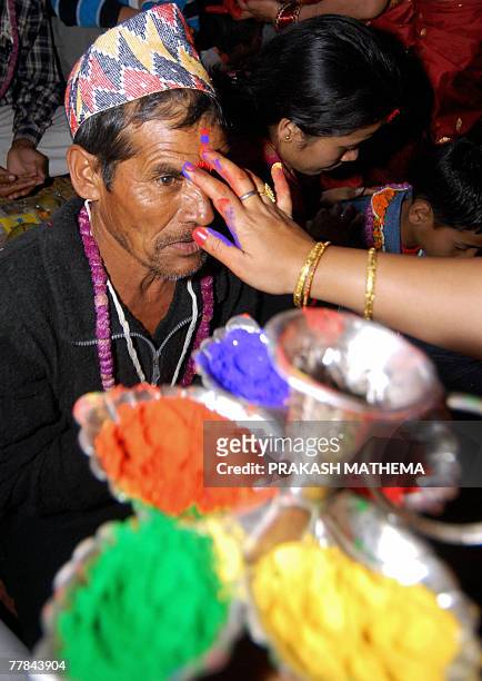 Nepalese woman applies a five-colour Tika on her brother's forehead on the occasion of Bhai Tika on the last day of the Hindu festival of Tihar in...