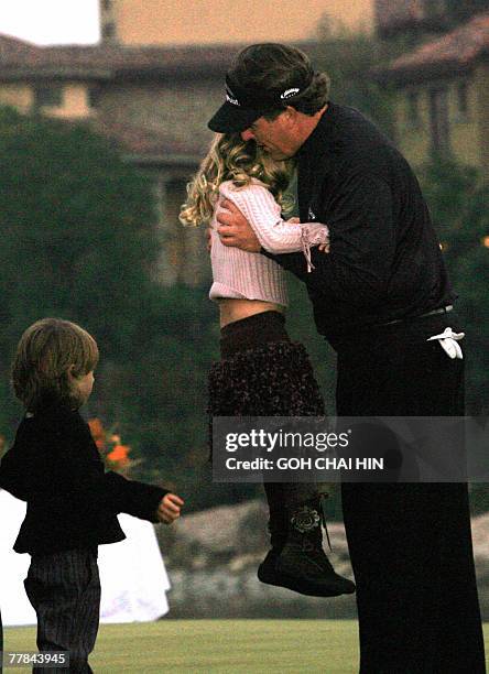 Phil Mickelson of the US hugs daughter Sophia Isabel while his son Evan waits his turn during the awards ceremony for the five-million-USD HSBC...