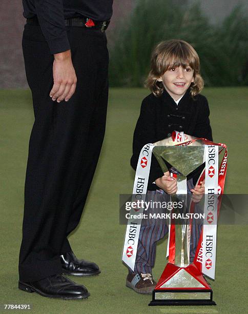 World number two Phil Mickelson of the US watches as his son Evan tries to lift the trophy after his father won the five million USD HSBC Champions...