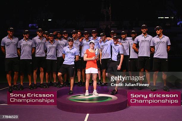 Justine Henin of Belgium celebrates with the trophy with the model ball boys after defeating Maria Sharapova of Russia in the final during day six of...