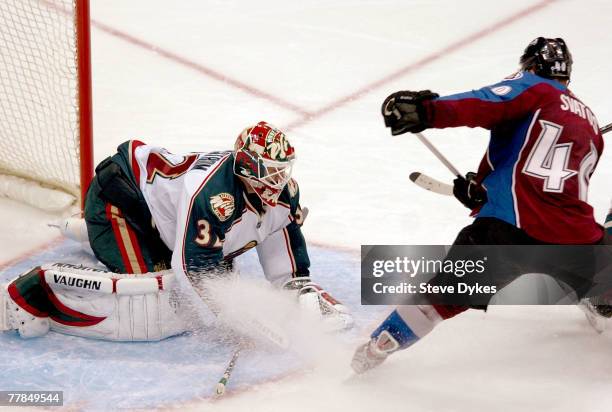 Goalie Niklas Backstrom of the Minnesota Wild goes out to challenge the shot of Marek Svatos of the Colorado Avalanche in front of the net in the...
