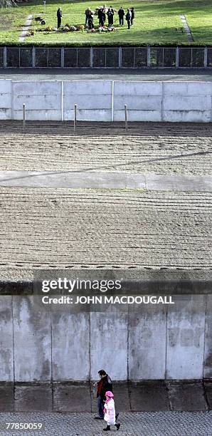 Germany-history-communism-wall,FEATURE by YANNICK PASQUET A picture taken 16 November 2004 shows a man and his child walking along a portion of the...