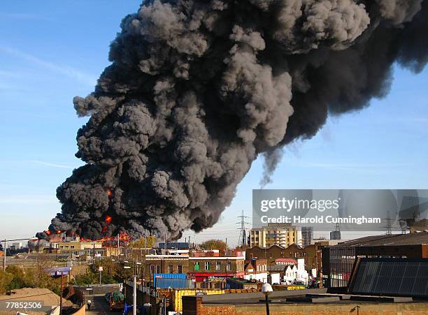 Flames and plumes of thick black smoke rise from a fire in the vicinity of Waterden Road, Hackney Wick on November 12, 2007 in London England. The...