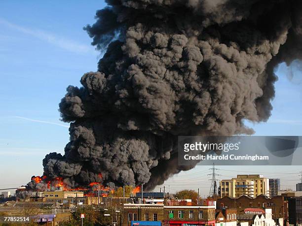 Flames and plumes of thick black smoke rise from a fire in the vicinity of Waterden Road, Hackney Wick on November 12, 2007 in London England. The...