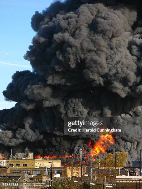 Flames and plumes of thick black smoke rise from a fire in the vicinity of Waterden Road, Hackney Wick on November 12, 2007 in London England. The...