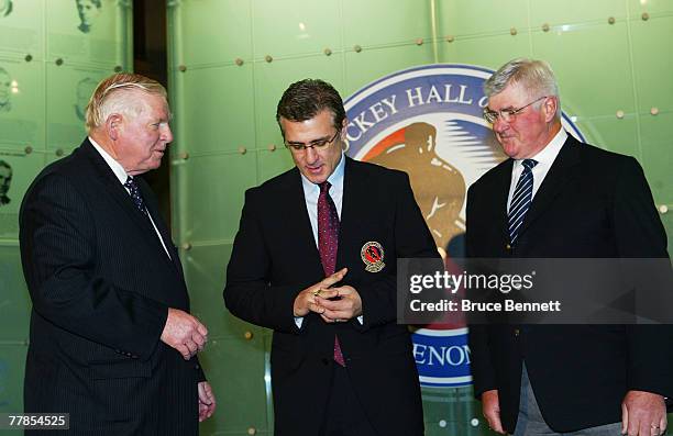 Chairman of the Hockey Hall of Fame Bill Hay presents the Hall ring to Rick Francis while Pat Quinn looks on at the Hockey Hall of Fame press...