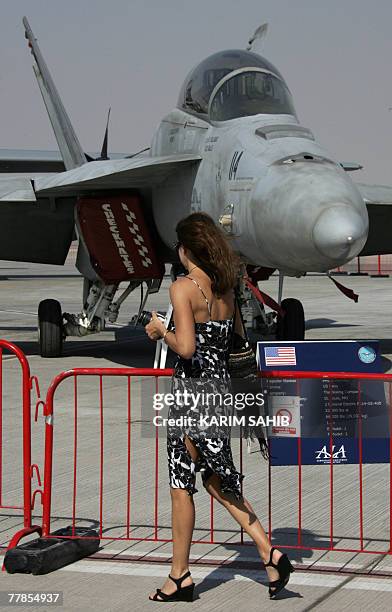 Visitor looks at a displayed US Air Force F-18 Hornet fighter jet during the 2nd day of the 2007 Dubai Airshow at Dubai airport, 12 November 2007....