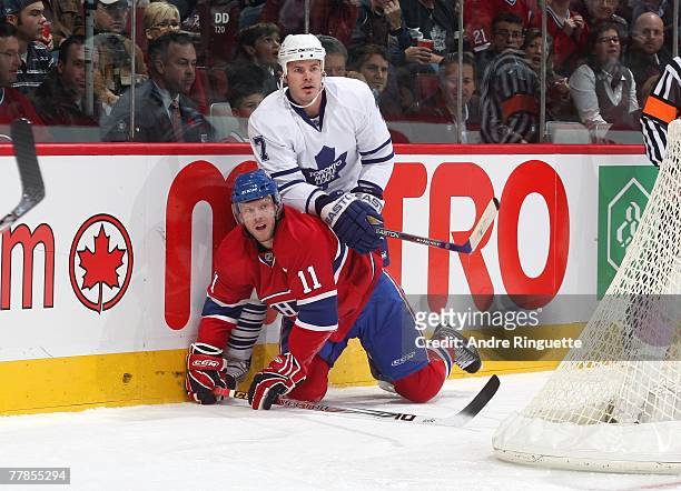 Ian White of the Toronto Maple Leafs tangles up with Saku Koivu of the Montreal Canadiens at the Bell Centre on November 3, 2007 in Montreal, Quebec,...