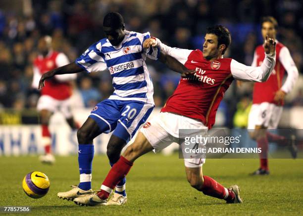 Arsenal's Spanish player Cesc Fabregas vies for the ball against Reading Emerse Fae the Premiership football match against Reading at the Madejski...