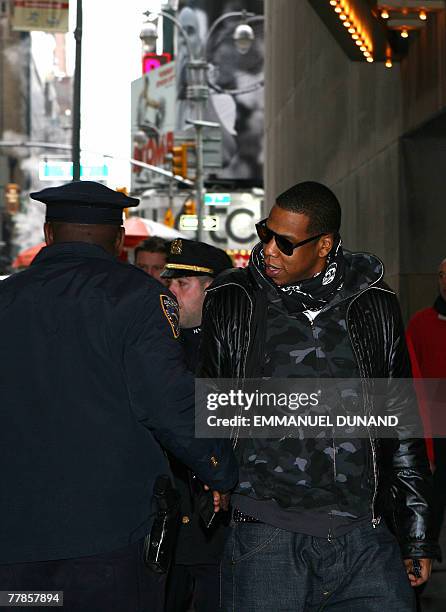 Rap singer Jay-Z shakes hands with a policeman as he arrives to attend MTV's Total Request Live at the MTV Times Square Studios in New York 12...