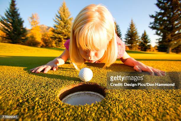 girl blows ball into hole - funny pics of people photos et images de collection
