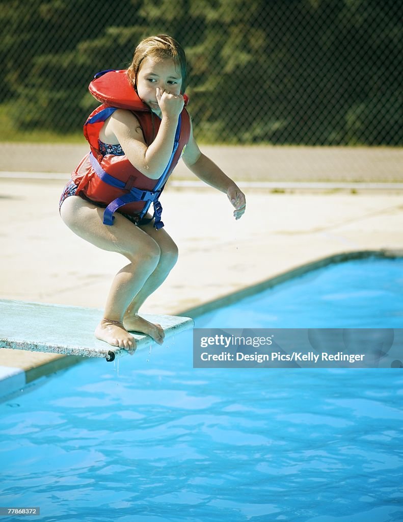 A child jumps off diving board