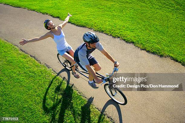 couple riding a tandem - hands free cycling - fotografias e filmes do acervo