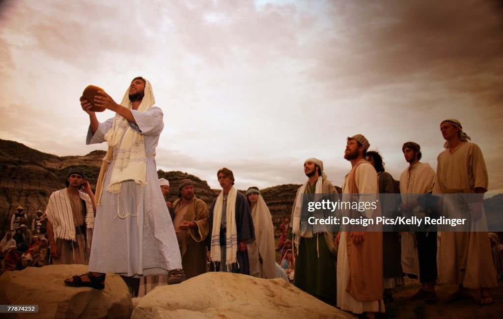 Disciples around as Jesus blesses bread