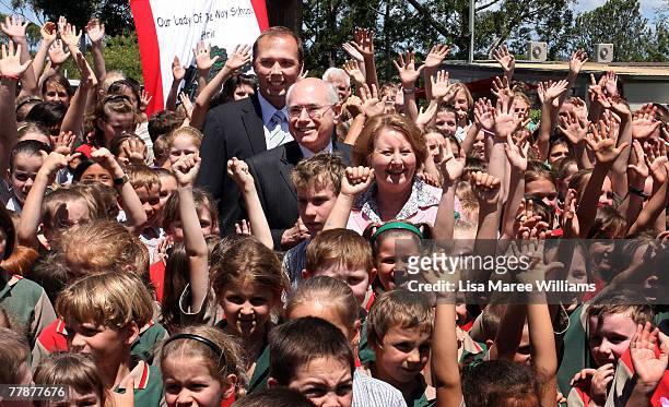 Prime Minister John Howard and wife Janette Howard pose with member for Dickson Peter Dutton and school students during a visit to Our Lady of the...