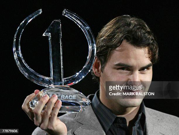 Roger Federer of Switzerland holds up the trophy for finishing the season rankings as number one during a ceremony at the 2007 Tennis Masters Cup...
